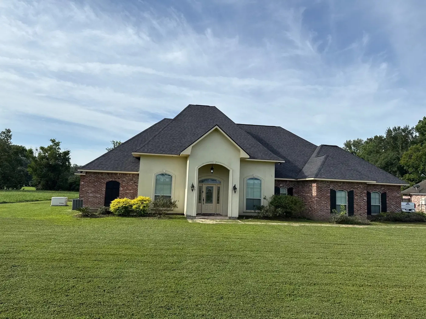 Completed architectural shingle roof on a brick and stucco home in Zachary, Louisiana after an insurance roof replacement