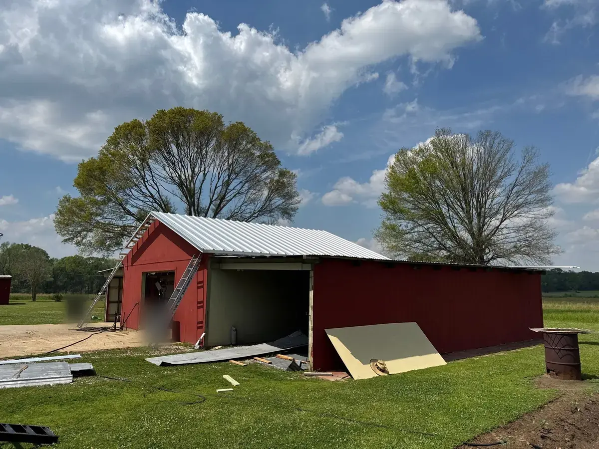 Finished new metal roof on the main gable of a red shop in Zachary, LA
