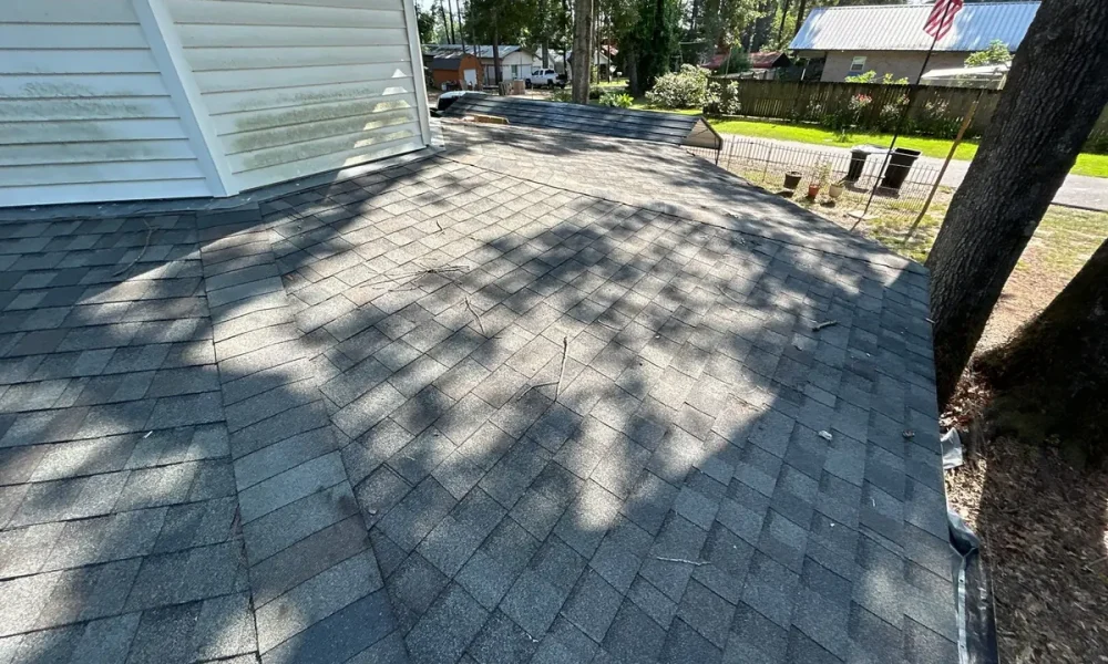 Weathered gray architectural shingles on an Ethel, Louisiana roof before replacement, beside a second-story wall