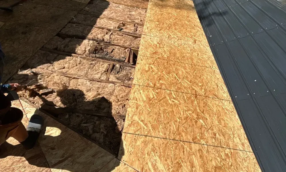 New OSB roof decking laid over the opened section next to the original deck and the metal porch roof