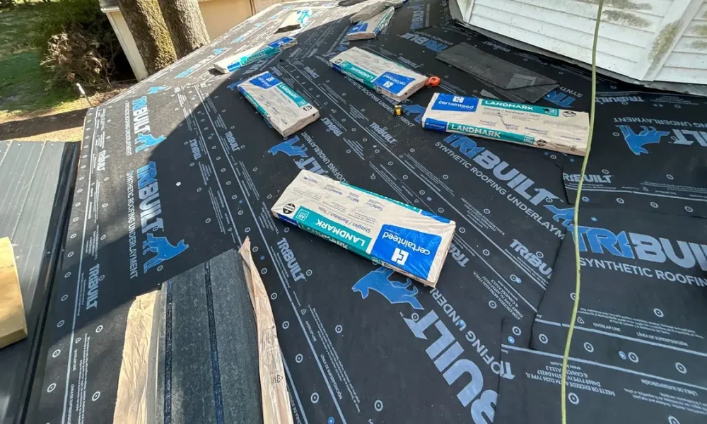 TriBuilt synthetic roofing underlayment covering the deck with CertainTeed Landmark bundles staged for install