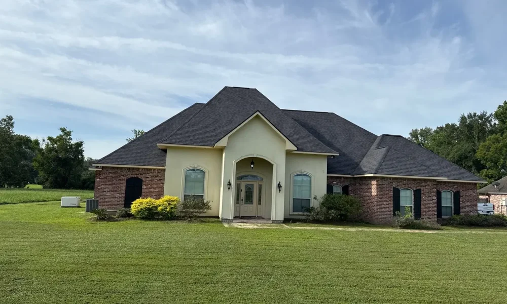 Completed architectural shingle roof on a brick and stucco home in Zachary, Louisiana after an insurance roof replacement