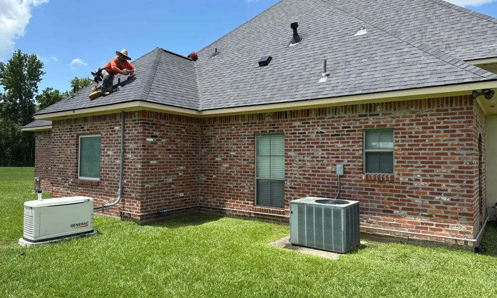 Roof Rescue crew member fastening new architectural shingles during a roof replacement in Zachary, Louisiana