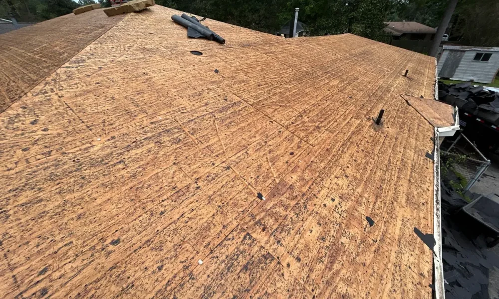 Roof deck stripped to bare wood sheathing during the tear-off on a Baker, Louisiana home