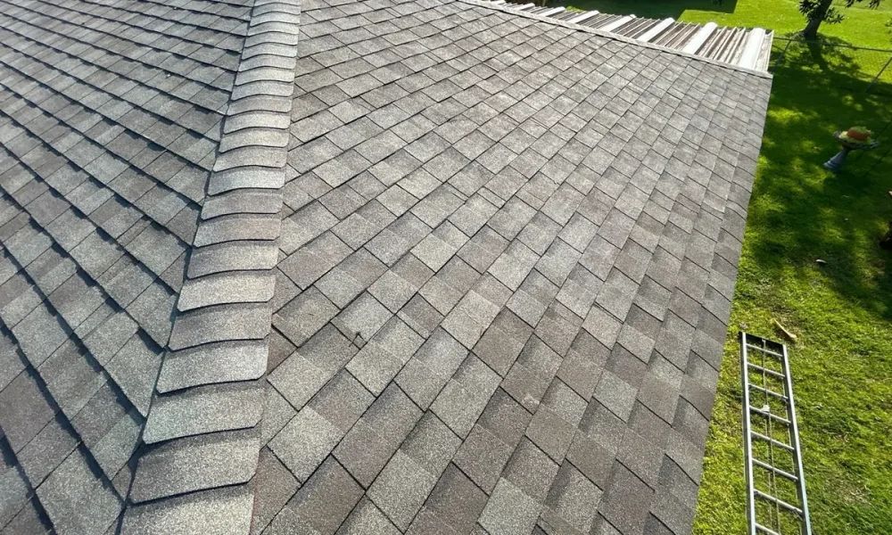 Completed architectural shingle hip roof with ridge cap running down the hip on a Baker, Louisiana home