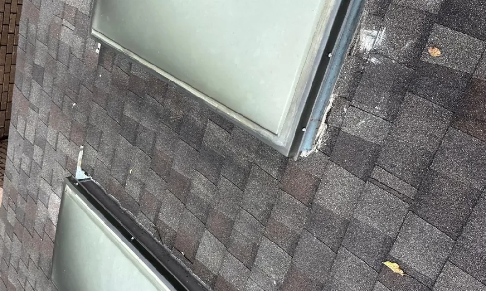 Two skylights with debris and worn sealant along their bases before the repair in Baker, LA