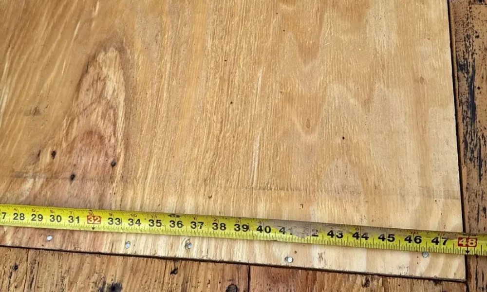 Tape measure across a new plywood sheet set into older board decking on a Baker, LA roof