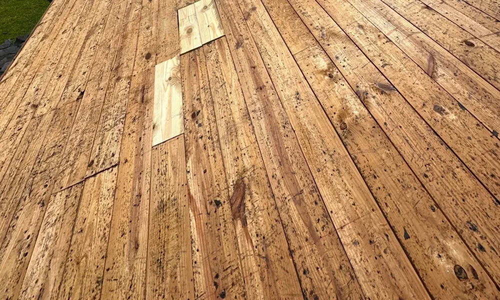 New pine boards patched into the original board decking before the underlayment went down