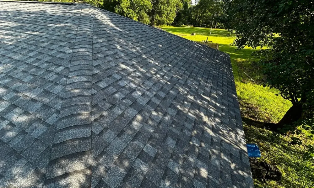 Finished hip roof in new gray architectural shingles with capped hip lines
