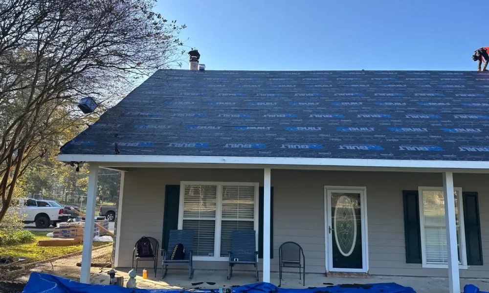 Synthetic underlayment complete on the Ethel roof, with tarps protecting the porch and landscaping below