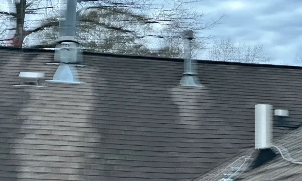 Old weathered shingle roof with streaked staining around the vent stacks on a Greenwell Springs, LA home before Roof Rescue replaced it