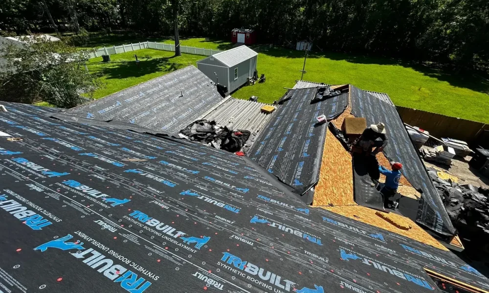 Roof Rescue crew working a valley over OSB decking while TriBuilt synthetic underlayment covers the surrounding roof in Greenwell Springs, LA