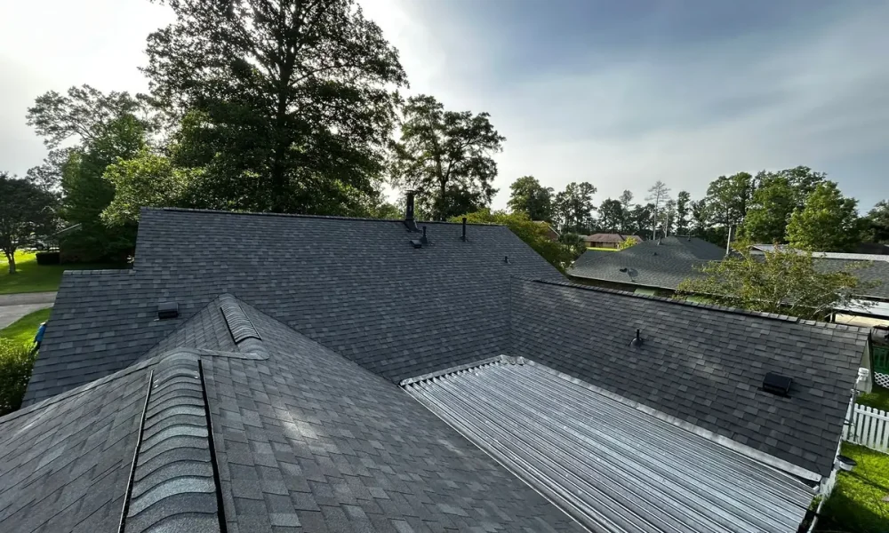 Completed shingle roof meeting a low-slope metal panel section at the back of a Greenwell Springs, LA home