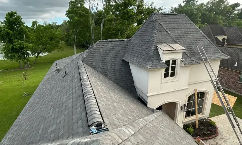 Finished roof with new ridge vent and hip caps below the front tower and dormer of the Saint Gabriel home