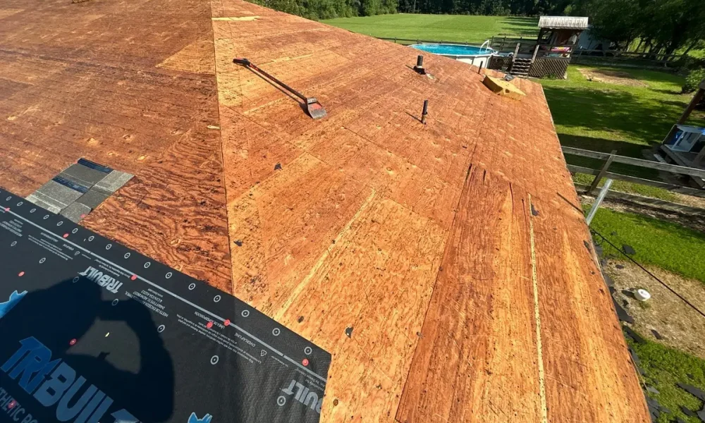 Bare decking with synthetic underlayment being rolled out across the Slaughter roof