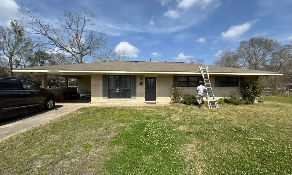 Ranch home in Slaughter, Louisiana before the roof replacement, with a Roof Rescue crew ladder set against the eave