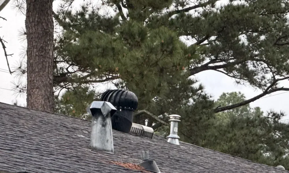 Turbine vent, box vent and pipe vents on the old shingle roof of a Central, LA home
