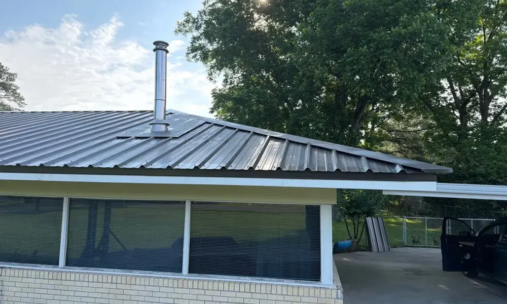 Finished dark metal roof and flue pipe over the back windows of a Central, LA home
