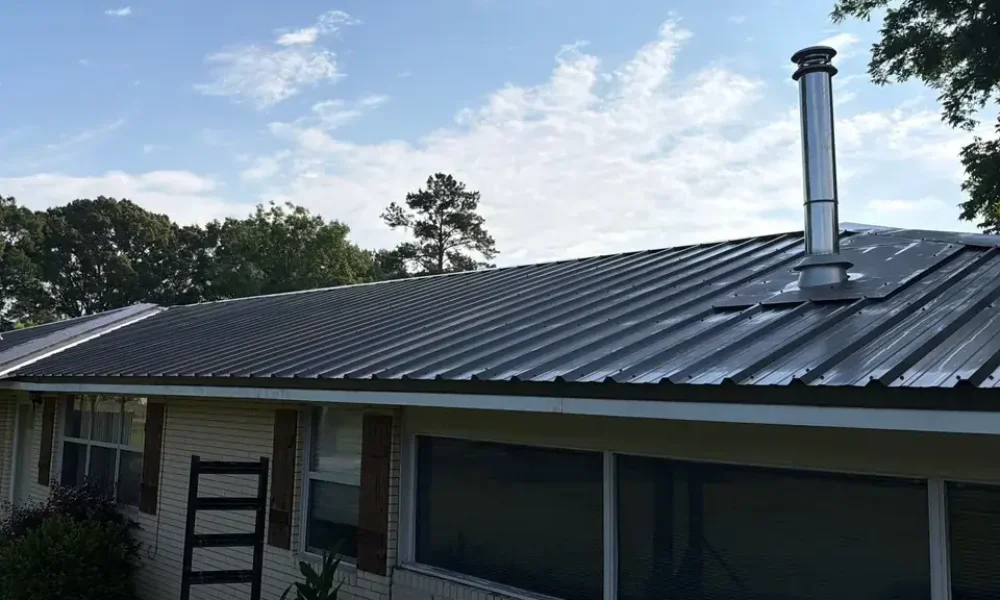 Long run of new dark metal roofing along a cream brick home in Central, LA