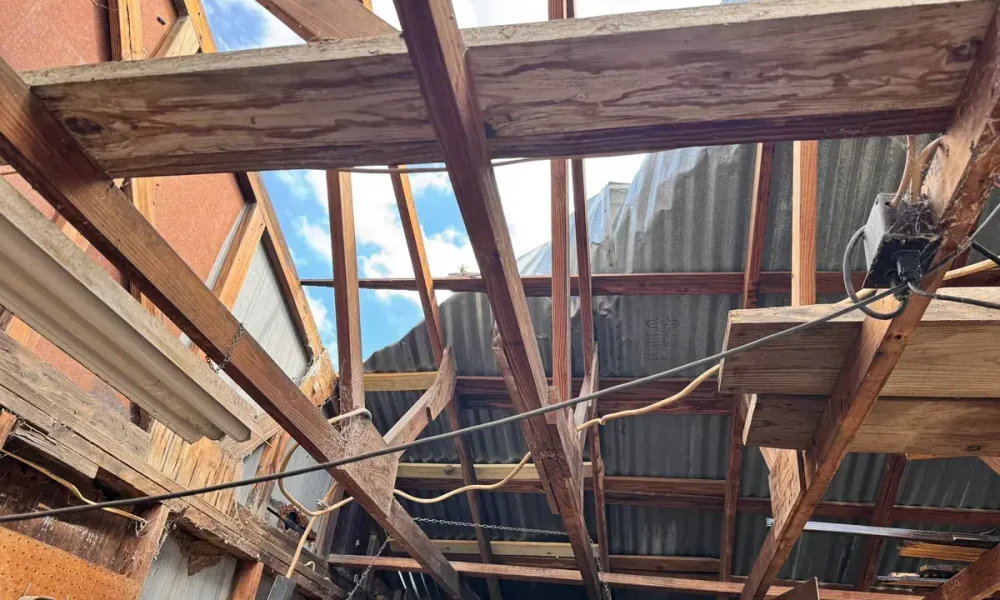 Shop rafters and lifted corrugated metal seen from inside a Zachary, LA building