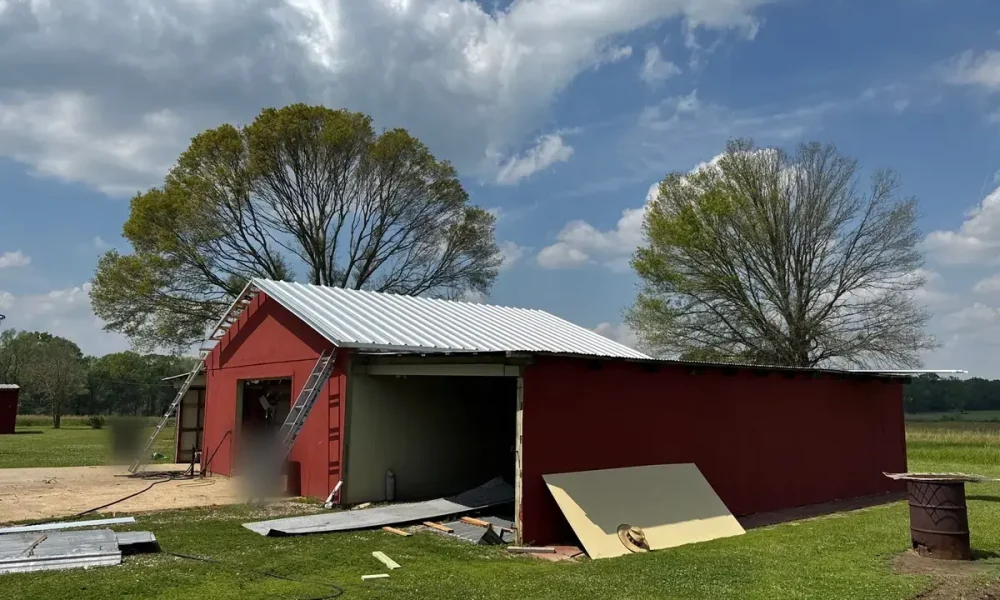 Finished new metal roof on the main gable of a red shop in Zachary, LA